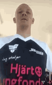 a man is wearing a black and white shirt that says ' hjarta ' on it .