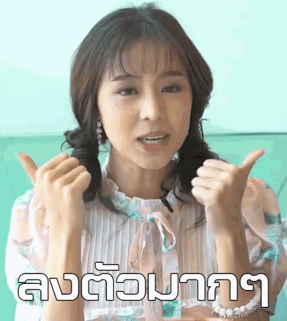 a woman is giving a thumbs up in front of a sign that says ' l' ' on it