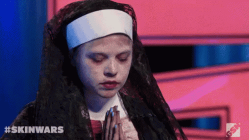a woman dressed as a nun is praying with her hands together