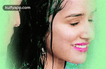 a close up of a woman 's face with water drops on it .