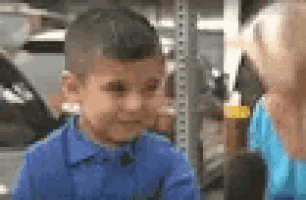 a young boy in a blue shirt is crying while talking to a woman in a blue shirt .