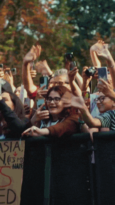a crowd of people at a concert with a sign that says asia