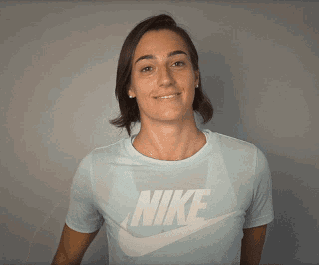 a woman wearing a light blue nike shirt