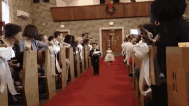 a flower girl walks down the aisle at a wedding