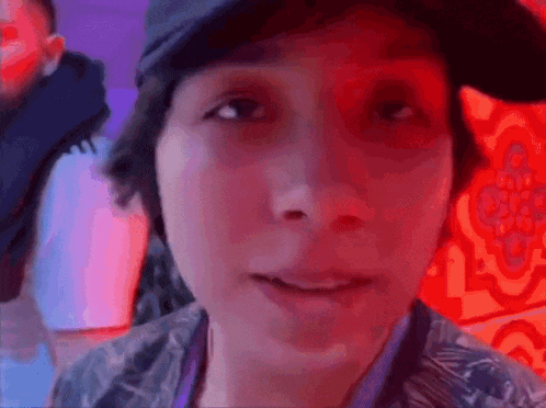 a close up of a person 's face with a red light behind them .