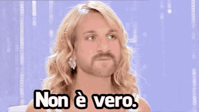 a man with long blonde hair and a beard says non è vero .