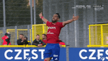 a soccer player is celebrating a goal in front of a sign that says czes