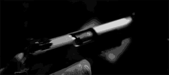it is a black and white photo of a person holding a gun .