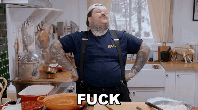a man in a blue shirt that says rvc is standing in a kitchen with his hands on his hips and the word fuck above him