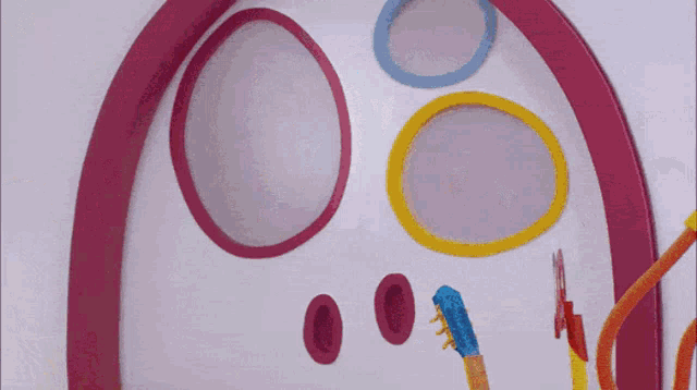 a pink circle with a hole in it is surrounded by other circles