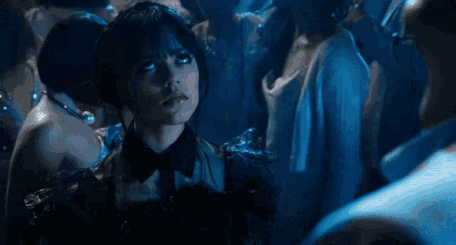 a man in a white suit is covered in blood while a woman looks on