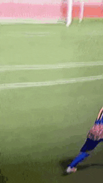 a soccer player is kicking a ball on a field .