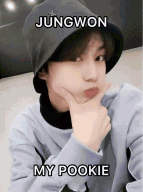 a young boy wearing a black bucket hat and a blue sweater with the words jungwon my pookie