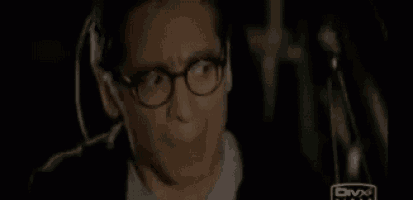 a man wearing glasses is sitting in a car with a divx logo on the bottom