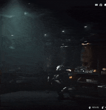 a man in a military uniform is holding a gun in a dark room with a rotate button in the corner