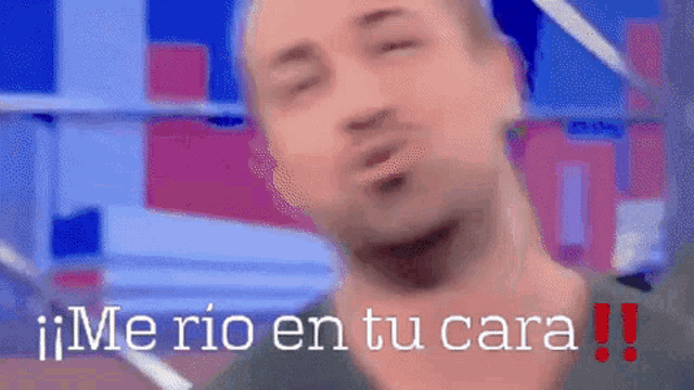 a blurry picture of a man with the words " me rio en tu cara " written below him