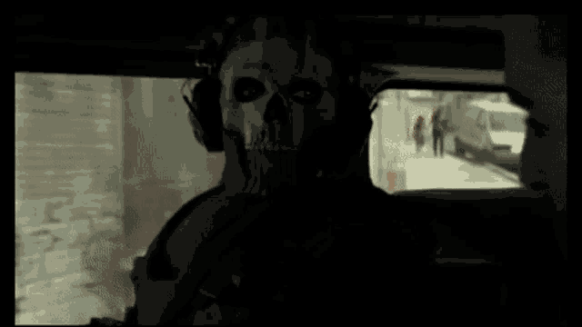 a man wearing a skull mask and headphones is sitting in a car