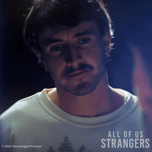 a poster for the movie all of us strangers shows a man with a beard