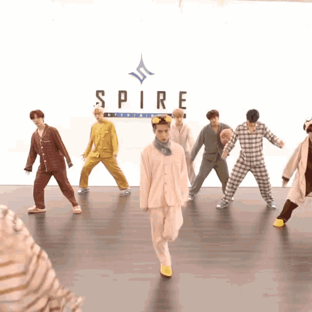 a group of people in pajamas are dancing in front of a sign that says spire