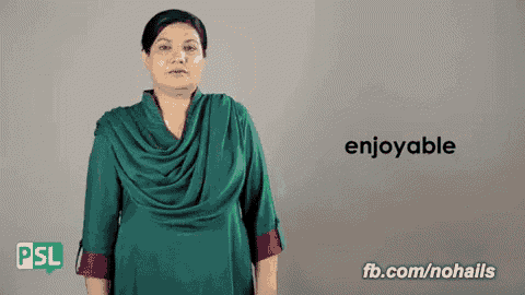 a woman in a green dress is giving a sign that says enjoyable .