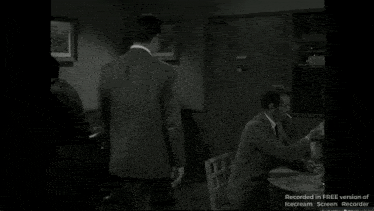 a man sitting at a table smoking a cigarette with the words recorded in free version of icecream screen recorder