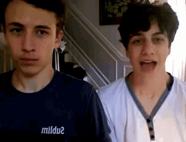 two young men are standing next to each other with one wearing a shirt that says mildu2 .