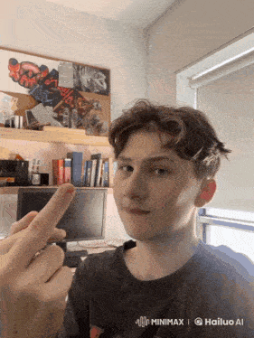 a young man in a black shirt is giving the middle finger