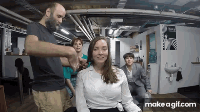 a man is cutting a woman 's hair in a hair salon .