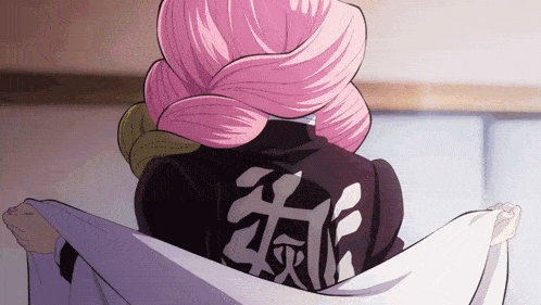 a girl with pink hair is wearing a black shirt with chinese writing on it