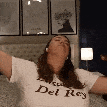 a woman is sitting on a bed with her arms outstretched .