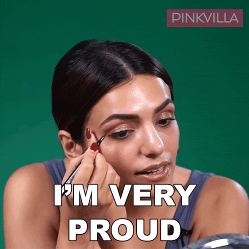 a woman applying makeup with the words " i 'm very proud " above her