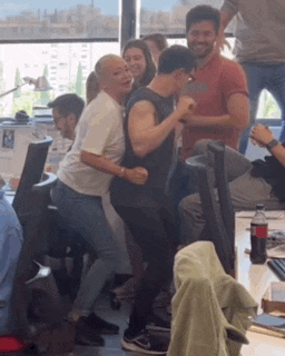a group of people are dancing in a room with a coca cola bottle in the background