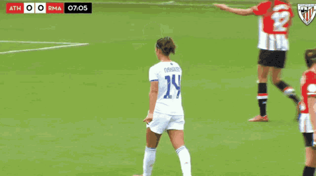 a female soccer player wearing number 14 stands on the field