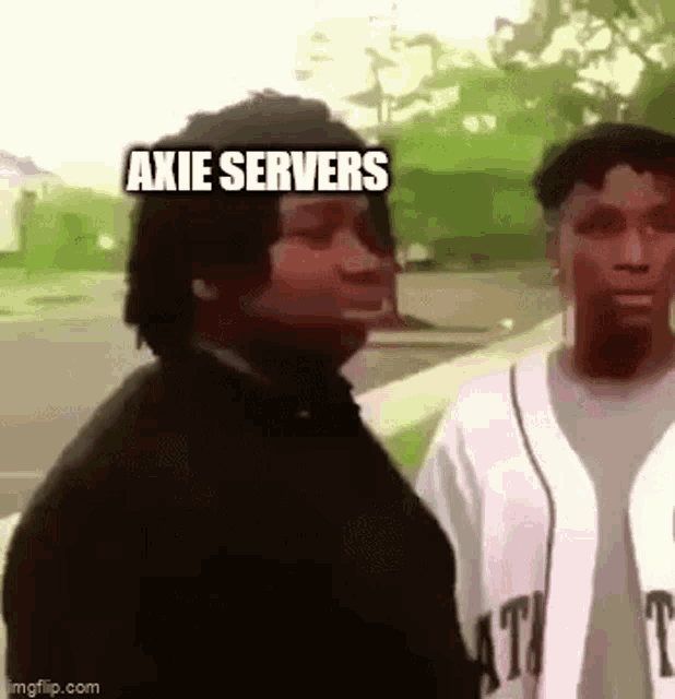 two men are standing next to each other on a sidewalk and one of them is saying `` axie servers '' .