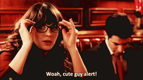 a woman wearing glasses says woah cute guy alert in front of a man in a suit