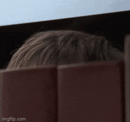 a man peeking over a fence with the words booze written on his face