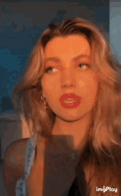 a close up of a woman 's face with red lipstick on her lips .