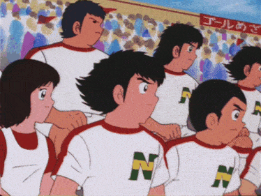a group of boys wearing shirts with the letter n on them stand in front of a crowd