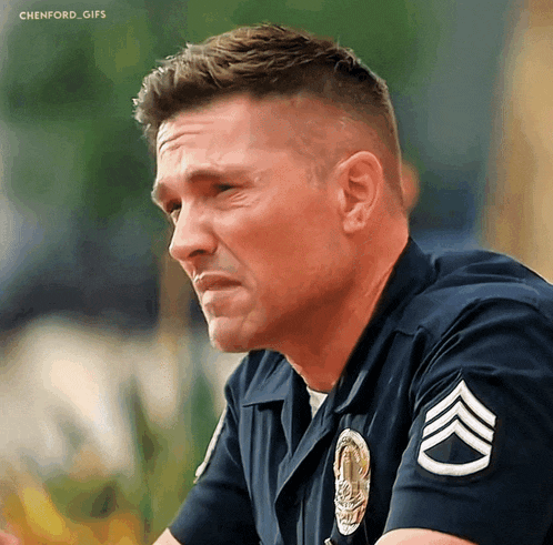 a close up of a police officer with a chevron on his sleeve