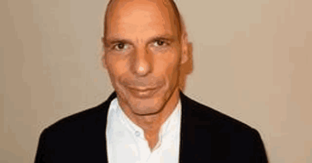 a bald man wearing a black jacket and a white shirt is smiling .