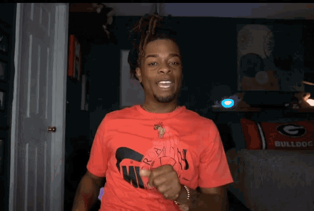 a man wearing a red nike shirt is pointing