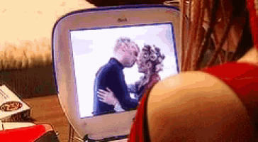 a person is looking at a picture of a man and woman kissing on a dell computer