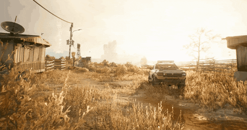 a car is parked in the middle of a field with a satellite dish in the background