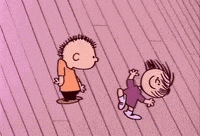 a boy and a girl are standing on a pink wooden floor .