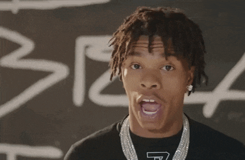a young man with dreadlocks is wearing a t-shirt that has the letter t on it