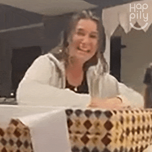 a woman sitting at a table with the word hap pillu on the bottom right
