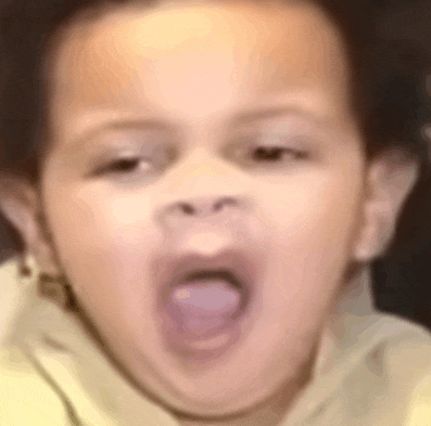 a close up of a child yawning with his mouth open .