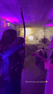 a little girl is holding a sword in a dark room with purple lights