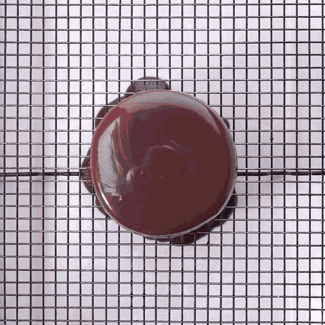 a chocolate covered donut is sitting on a cooling rack