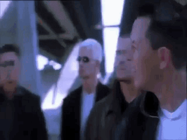 a group of men are standing next to each other on a train .